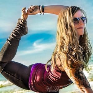 Photo of woman wearing sunglasses doing a yoga pose - the dancer