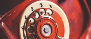 Photo of closeup of red rotary telephone